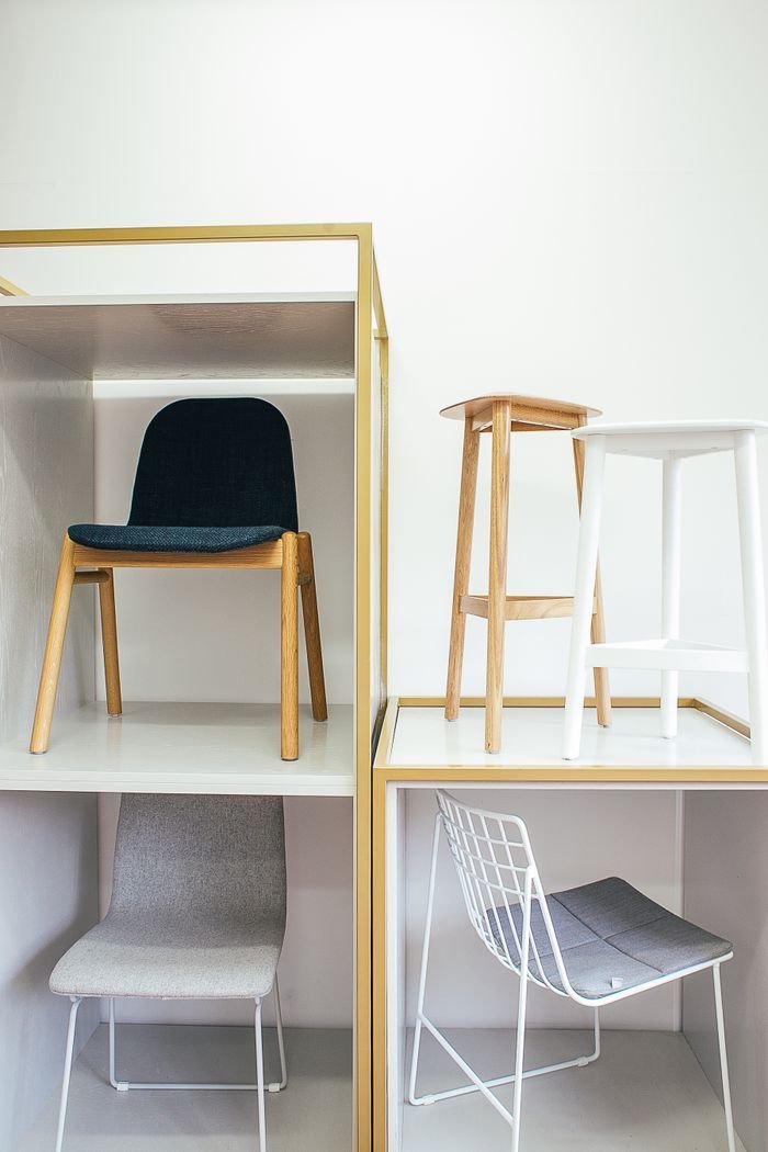 Abstract interior of room with white wall and various chairs placed in boxes and near each other